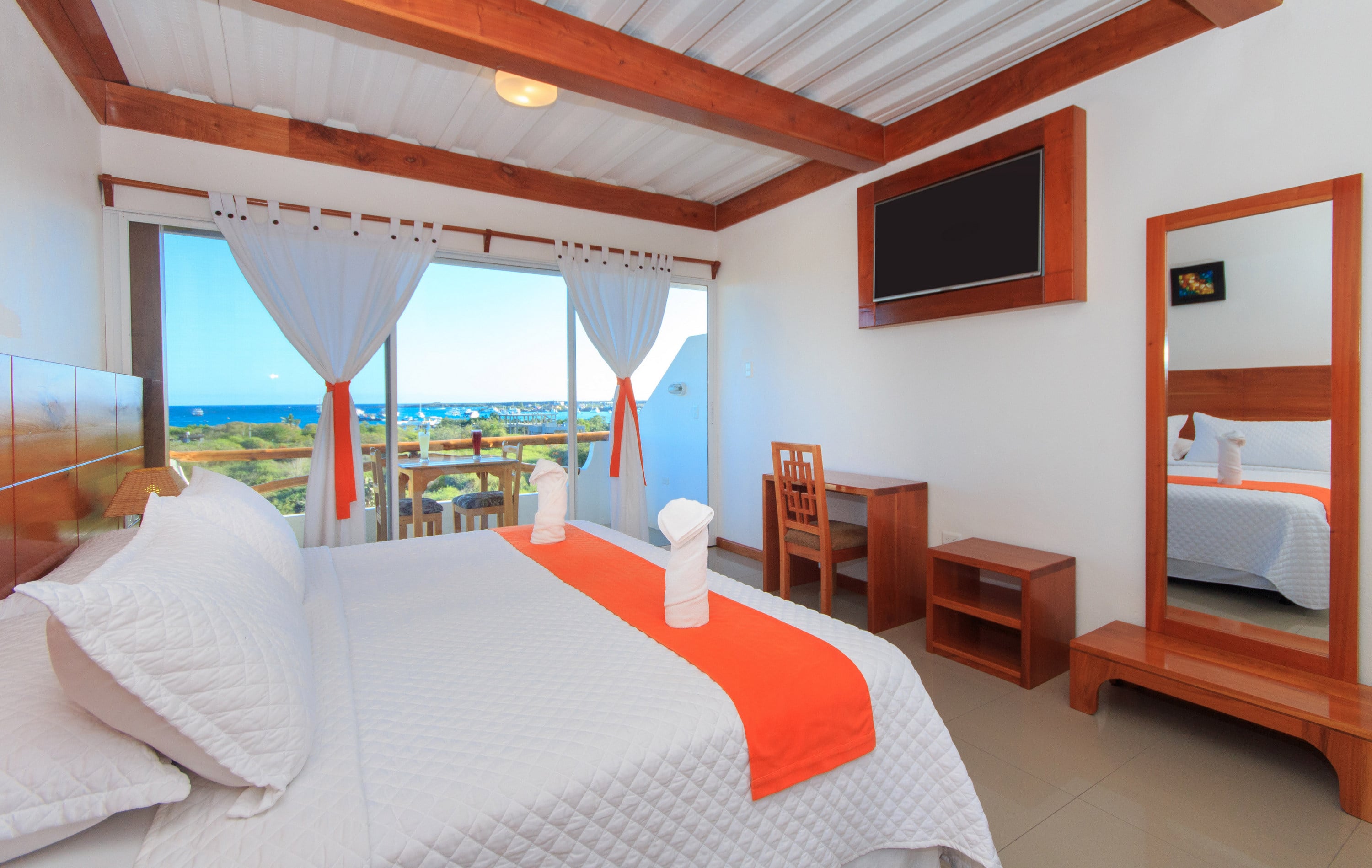 Single room with wooden furniture, ocean view, and clean decor.