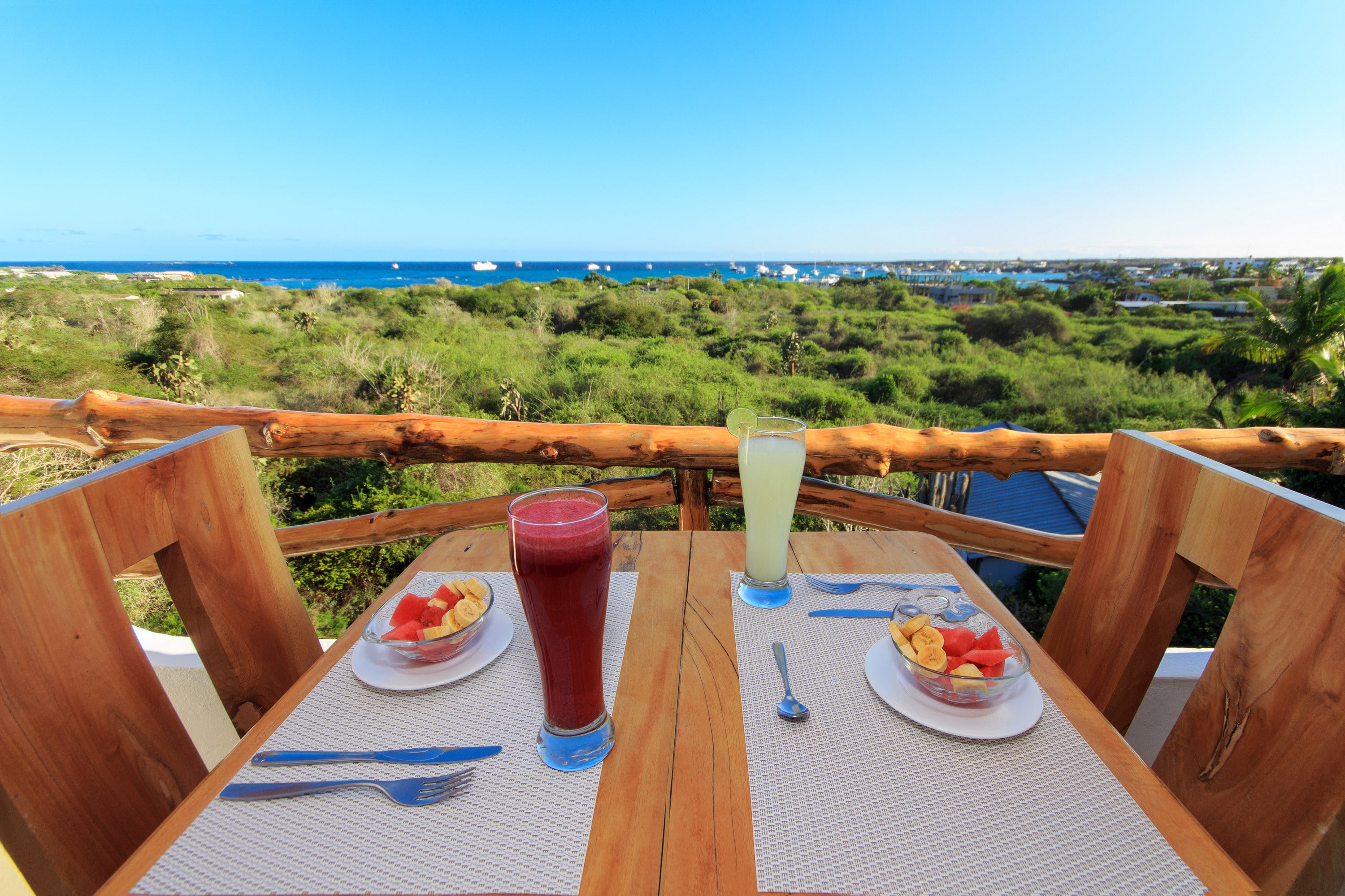 Balcony with a breakfast table and ocean view in the background.