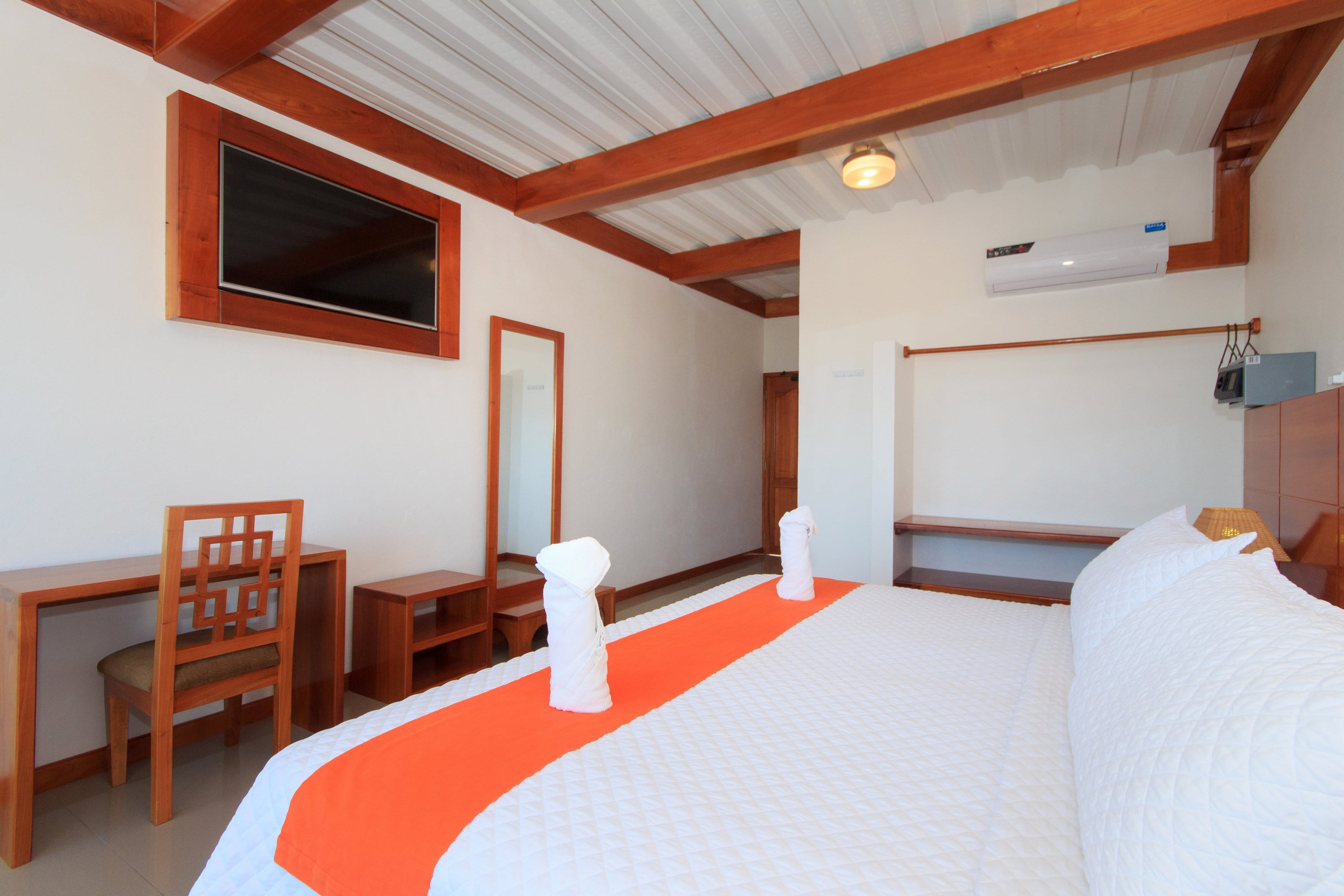 Single room with ocean view, wooden furniture, a TV, and clean decor.