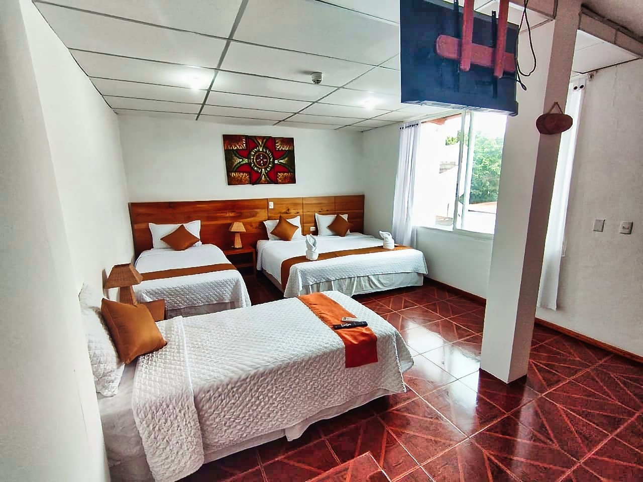 Triple-bed room with wooden furniture, clean decor, and ample space.