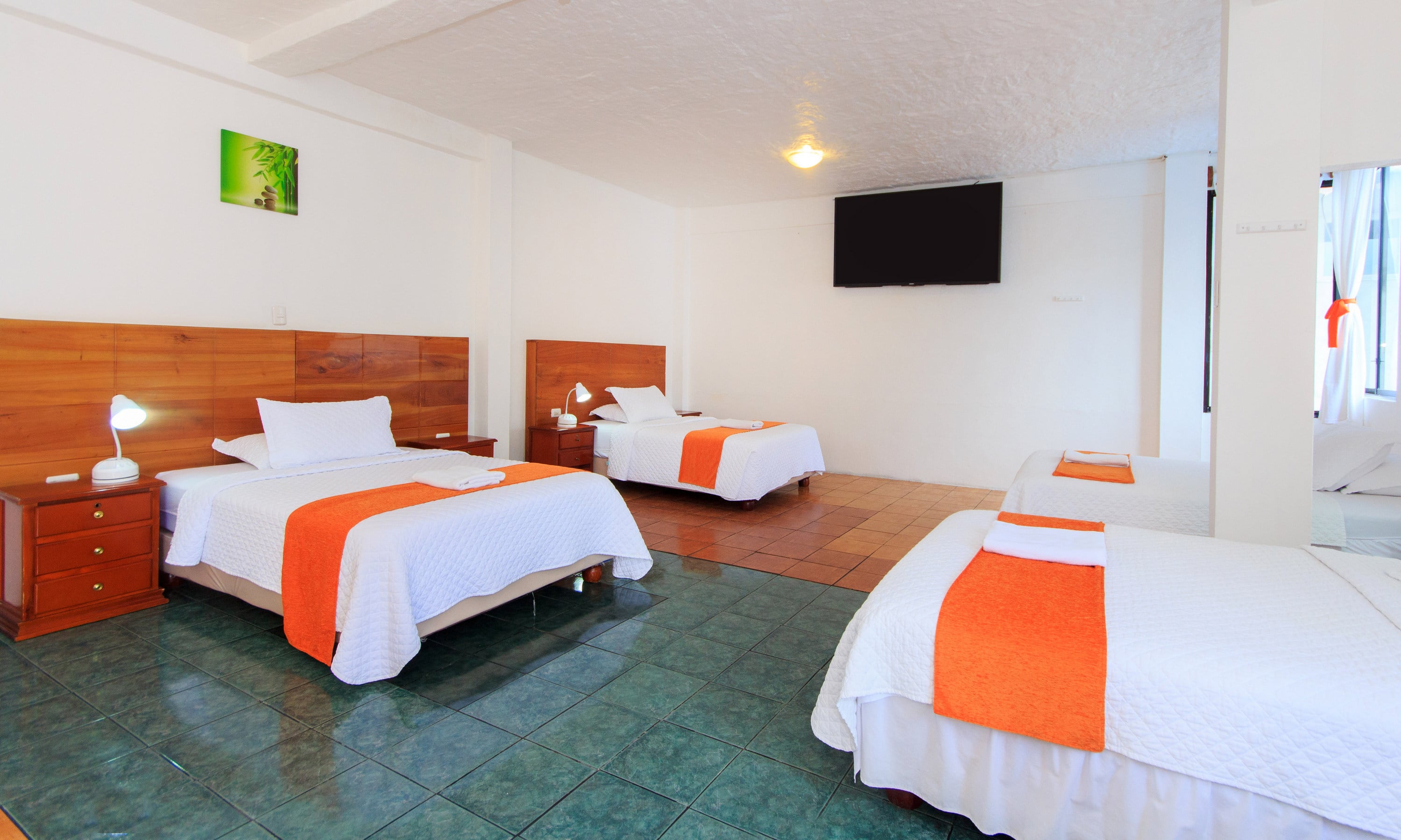 Triple-bed room with three beds, a mirror, ocean view, and a TV.