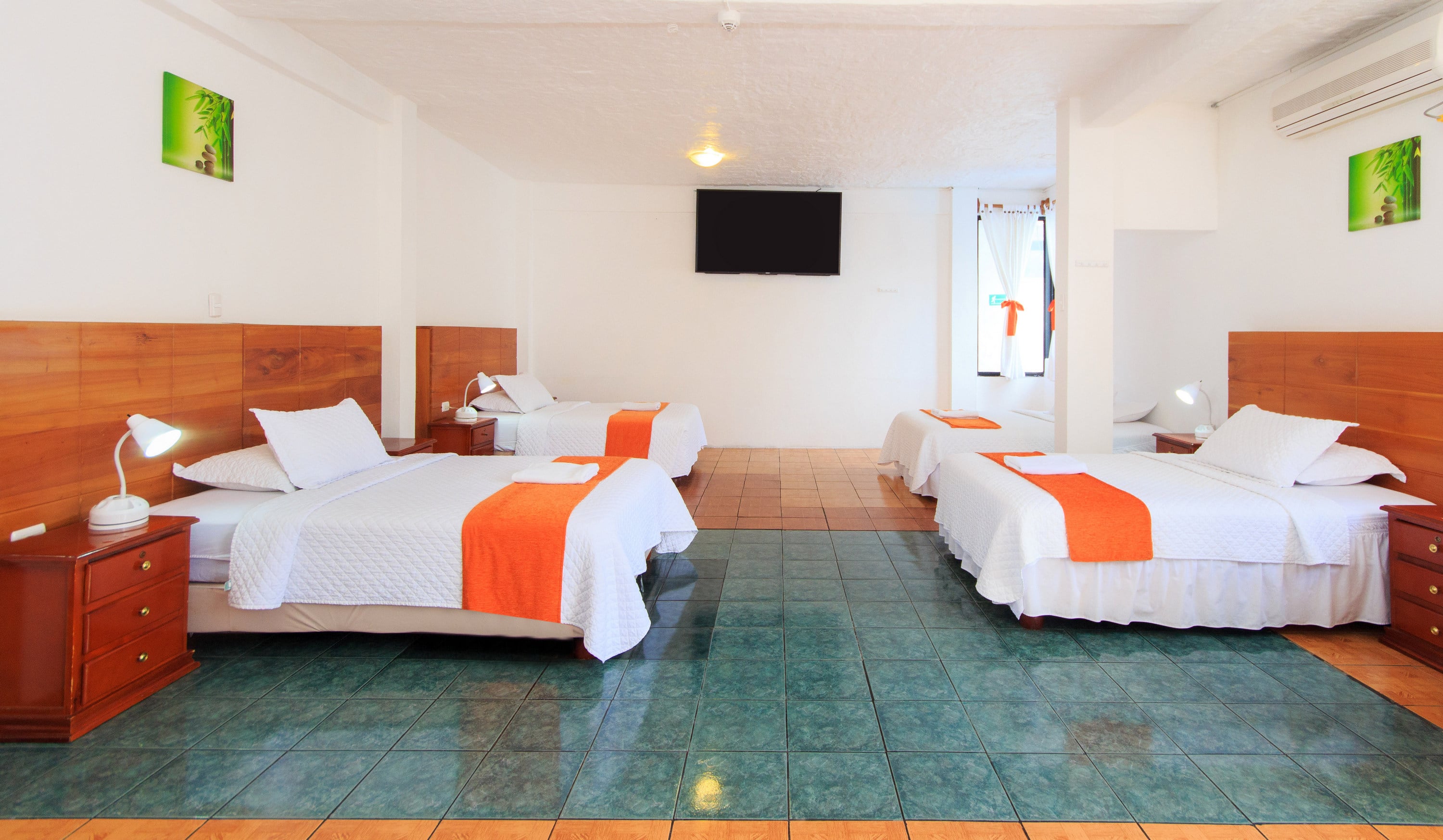 Triple-bed room with three beds, a mirror, ocean view, and a TV.